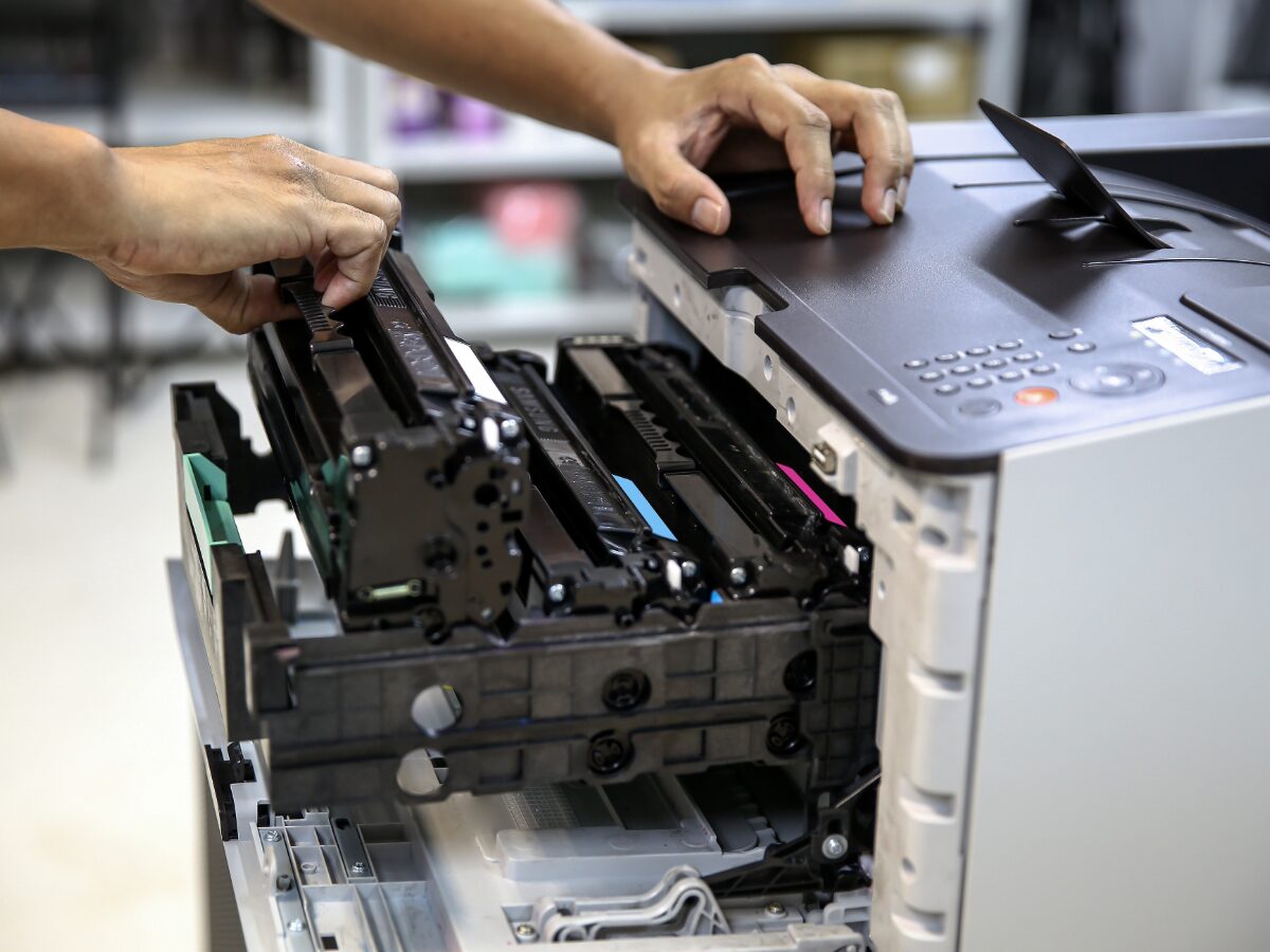 Professional Document Solutions technician servicing a color laser printer